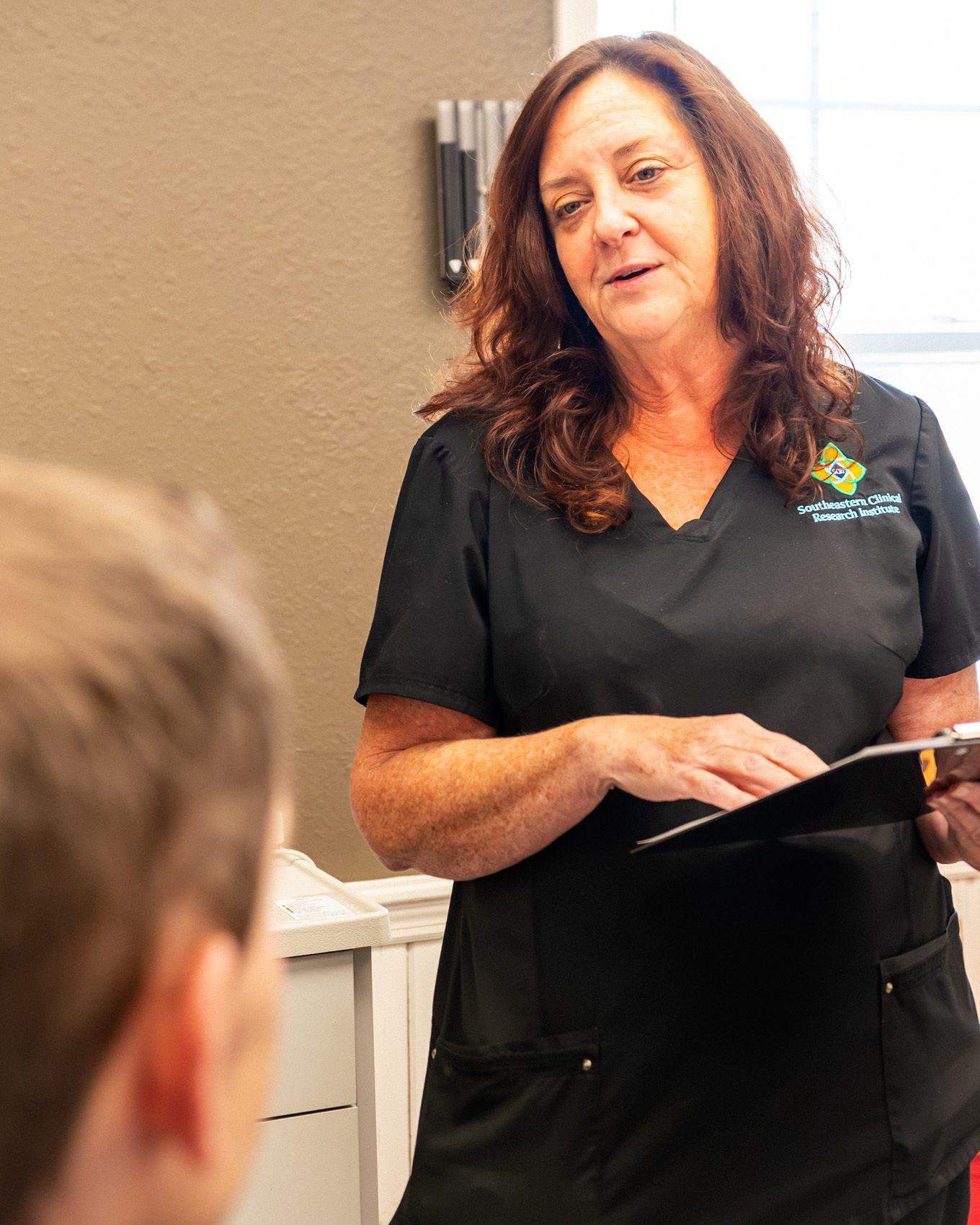 A research coordinator talking with a patient